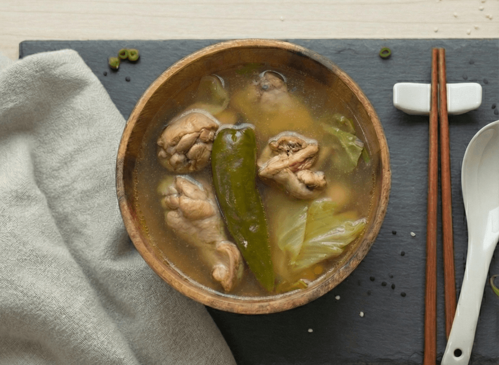 Soba Lab 剝皮辣椒雞湯：木碗清雞湯俯拍，辣椒與雞肉