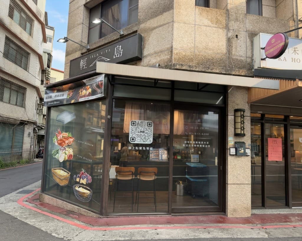 輕島 ISLA VITA 轉角店面：大片玻璃、店招、櫥窗圖像與線上點餐 QR Code